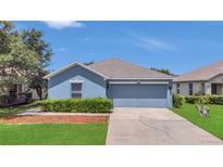 Charming blue single-story home with a well-manicured lawn and a two-car garage at 5145 Prairie View Way, Wesley Chapel, FL 33545