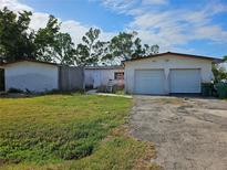 Single-story home with a two-car garage and lawn needing maintenance and some updates at 801 Marlin Dr, Punta Gorda, FL 33950