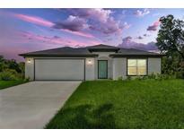 Charming one-story home with a lush lawn, modern design and attached two-car garage at 4798 Jody Ave, North Port, FL 34288