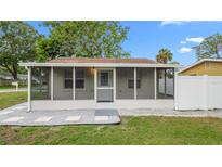 Charming home featuring a screened front porch, grey stone landscaping and ample sunlight at 7635 Pier Rd, Port Richey, FL 34668