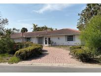 Charming single-story home with a beautiful red tile roof and circular brick driveway at 568 Venice Ln, Sarasota, FL 34242