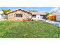 Charming single Gathering home with a stone facade and well-manicured front lawn at 8744 Candlewick Ln, Port Richey, FL 34668