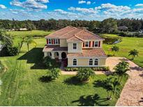 Stunning two-story home featuring a tile roof, lush landscaping, and a brick driveway at 7315 Bianco Duck Ct, Sarasota, FL 34240