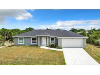 Single-story home with gray exterior and a two-car garage at 12128 Grouse Ave, Port Charlotte, FL 33981