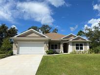New construction home with attached garage and landscaped lawn at 3481 Nashville Rd, North Port, FL 34288