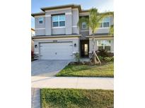 Two-story house with gray exterior, landscaping, and driveway at 3101 Hollow Hickory Pl, Wesley Chapel, FL 33543