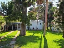 Quaint waterfront cottage with lush lawn and mature trees at 7316 Tropical Dr, Weeki Wachee, FL 34607