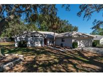 One-story house with a two-car garage and palm trees in the front yard at 15123 Copeland Way, Spring Hill, FL 34604