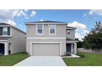 Charming two-story home with a two car garage and well-manicured lawn at 30942 Wild Juniper Ct, Brooksville, FL 34602