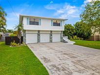 Two-story home featuring a three-car garage, stone accents, and a well-manicured lawn at 1731 Clearwater Harbor Dr, Largo, FL 33770