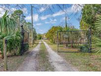 Gated entrance and long driveway leading to the property, offering privacy and seclusion at 8279 Sunshine Grove Rd, Brooksville, FL 34613