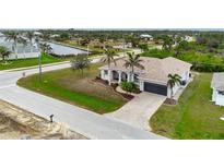 Beautiful home with a paver driveway, lush lawn and decorative palm trees at 8305 Welsford Rd, Port Charlotte, FL 33981
