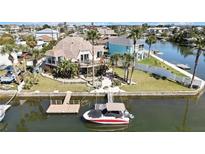 Waterfront home featuring tropical landscaping, a private dock, and easy access to the canal at 4446 Bahama Dr, Hernando Beach, FL 34607