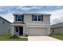 Charming two-story home with a two-car garage and beautiful blue shutters in a well manicured lawn at 30926 Silver Stage Dr, Brooksville, FL 34602