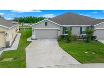 Charming single-story home with a well-manicured lawn and attached two-car garage at 17663 Turning Leaf Cir, Land O Lakes, FL 34638