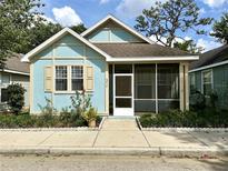 Charming blue single-story home with a screened-in porch and well-maintained landscaping at 6212 Abbott Station Dr, Zephyrhills, FL 33542