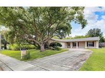 Charming single-story home featuring a well-manicured lawn, mature trees, and a long driveway at 2140 N Bay Hills Blvd, Safety Harbor, FL 34695