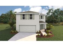 Two-story home featuring a neutral color scheme, attached garage, manicured lawn, and complementary landscaping at 30948 Silver Stage Dr, Brooksville, FL 34602