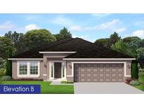 Charming single-story home featuring neutral paint, a dark roof, an attached two-car garage, and manicured landscaping at 4841 Sutherland St # Lot 58, Spring Hill, FL 34609