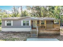 Charming home featuring a cozy front porch and well-maintained siding in a peaceful, wooded setting at 6008 Angus Valley Dr, Wesley Chapel, FL 33544