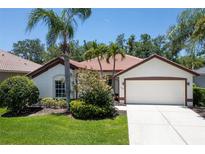 Charming single-story home boasts lush landscaping, a two-car garage, and a clay tile roof at 3389 Pennyroyal Rd, Port Charlotte, FL 33953
