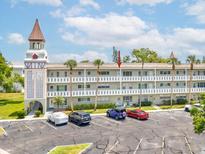 Charming condo building featuring a unique tower, well-maintained landscaping, and ample parking at 2401 Ecuadorian Way # 45, Clearwater, FL 33763