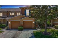 Charming townhome featuring a two-car garage, landscaped front yard, and neutral exterior paint at 4510 Limerick Dr, Tampa, FL 33610