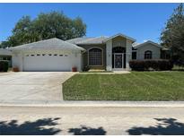 Charming single-story home with a two-car garage, well-manicured lawn, and inviting curb appeal at 9685 Southern Belle Dr, Weeki Wachee, FL 34613