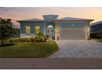 Charming single-Gathering home with a well-manicured lawn and a two-car garage at sunset at 10391 Coquina Ct, Placida, FL 33946