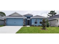 Charming single-story home with a blue facade, stone accents, and well-maintained lawn at 13243 Gulf Bay Ln, Spring Hill, FL 34609