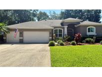 Charming single-story home featuring a well-manicured lawn, three-car garage, and mature landscaping at 1138 Lumsden Trace Cir, Valrico, FL 33594