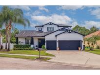 Charming two-story home featuring a two-car garage, manicured lawn, and beautiful landscaping at 205 Bengal Cir, Oldsmar, FL 34677