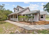 Charming two-story home with a welcoming front porch and well-maintained landscaping at 10230 289Th E St, Myakka City, FL 34251