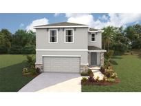 Charming two-story home featuring a two-car garage, a beautifully landscaped yard, and classic architectural details at 10460 Tucker Rd, Weeki Wachee, FL 34613