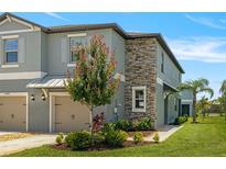 Charming townhome with a stone facade, well-maintained landscaping, and an attached two-car garage at 14347 Easy Goer St, Ruskin, FL 33573