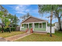 Charming single-story home featuring a welcoming front porch, green siding, and well-maintained landscaping at 2715 14Th N Ave, St Petersburg, FL 33713