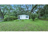Charming single-story home with a well-maintained lawn and mature trees providing ample shade at 242 Zoller St, Brooksville, FL 34601