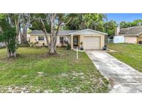 Charming single-story home featuring a well-manicured lawn and a one-car garage at 7318 Tranquil Dr, Spring Hill, FL 34606