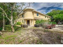 Tan two-story home with a unique rounded front and landscaping at 6628 1St N St, St Petersburg, FL 33702