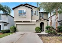 Two story house with a two-car garage and landscaping at 12730 Lemon Pepper Dr, Riverview, FL 33578