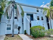 Light blue building exterior with palm trees and landscaping at 7108 Waterside Dr # 103, Tampa, FL 33617