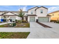 Modern townhomes featuring well-maintained lawns and two-car garages, plus stylish landscaping, and neutral color schemes at 5327 New Friendship Pl, Tampa, FL 33619