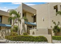 Exterior of a tan condo building with lush landscaping and a well-maintained facade at 722 Pinellas Bayway S # 102, St Petersburg, FL 33715