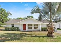 Charming single-story home featuring a bright red front door and lush lawn at 1103 W Dixie St, Plant City, FL 33563