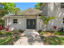 Inviting front entrance featuring double doors, lush landscaping, and a well-maintained walkway at 6317 Discovery Ln, Land O Lakes, FL 34638