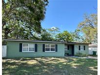 Charming single-story home featuring a well-maintained lawn, traditional windows with shutters, and mature shade trees at 1808 Heather Ave, Tampa, FL 33612