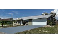 Charming single-Gathering home featuring a neatly painted exterior, gray roof, and a convenient two-car garage at 1735 Council Dr, Sun City Center, FL 33573