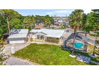Charming home boasts a metal roof, inviting front porch, and screened-in pool, perfect for relaxation at 3620 E Tampa Cir, Tampa, FL 33629