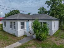 Charming white house with a blue door and a well-kept yard, creating a welcoming curb appeal at 602 E Laura St, Plant City, FL 33563