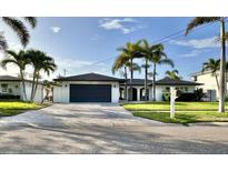 Modern home with a sleek design, palm trees, well-manicured lawn, and a spacious driveway at 320 Palm Ne Is, Clearwater Beach, FL 33767